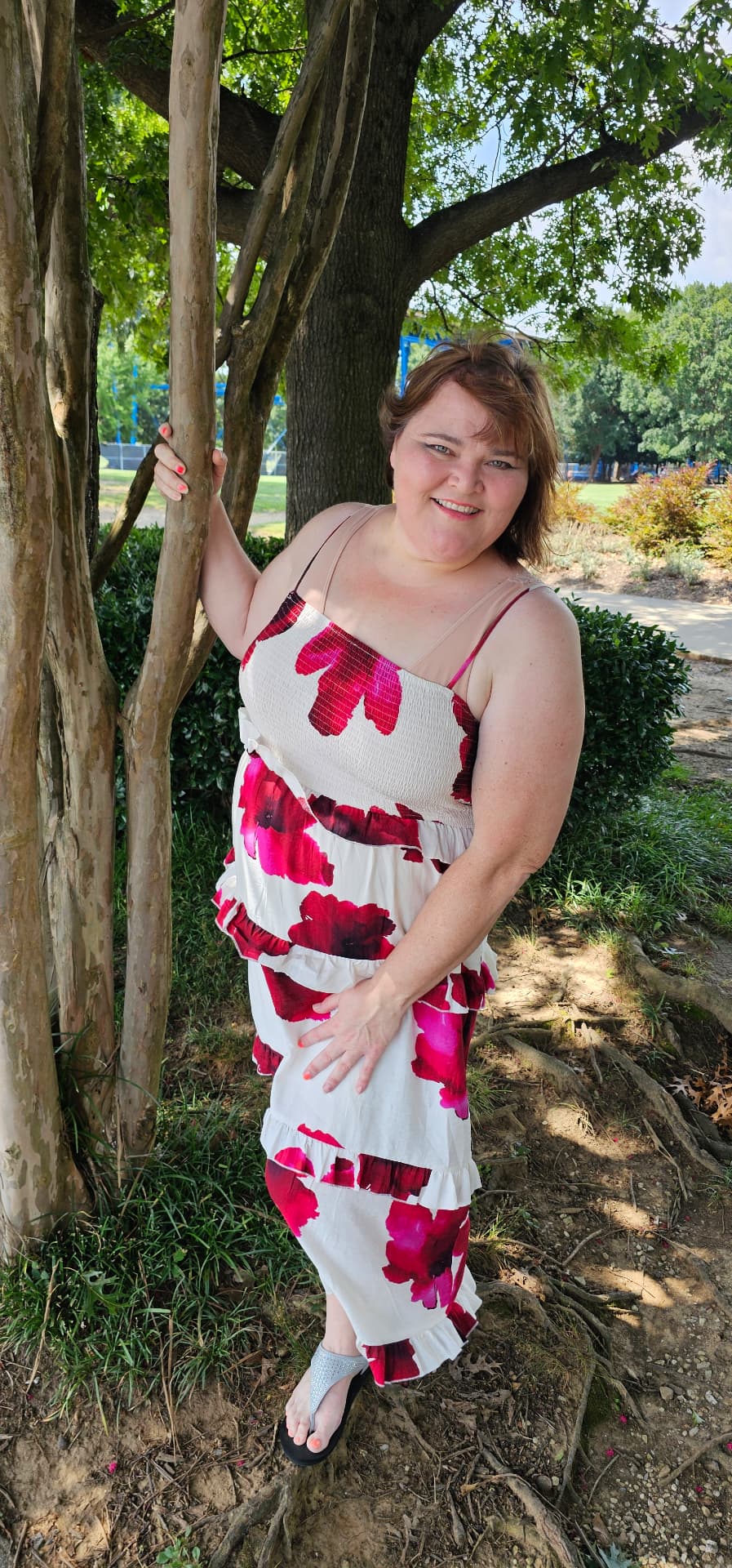 Myra smirking beside the tree