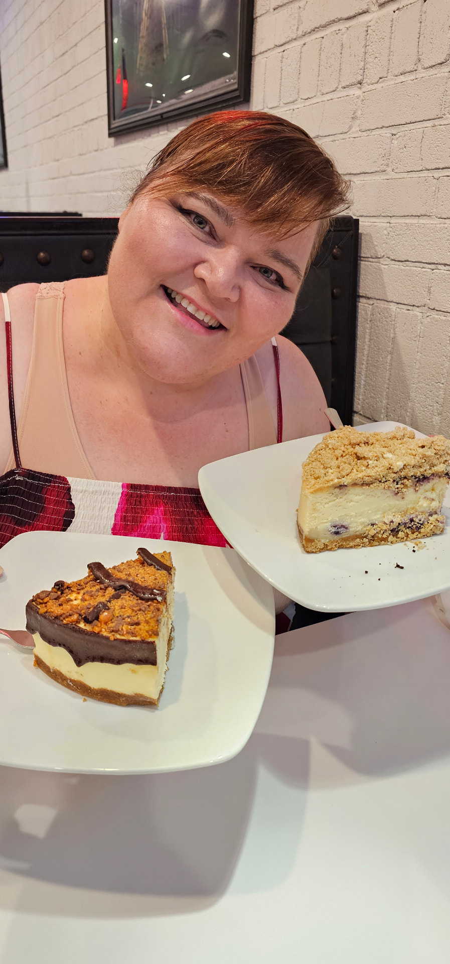 Myra holding two slices of cheesecake