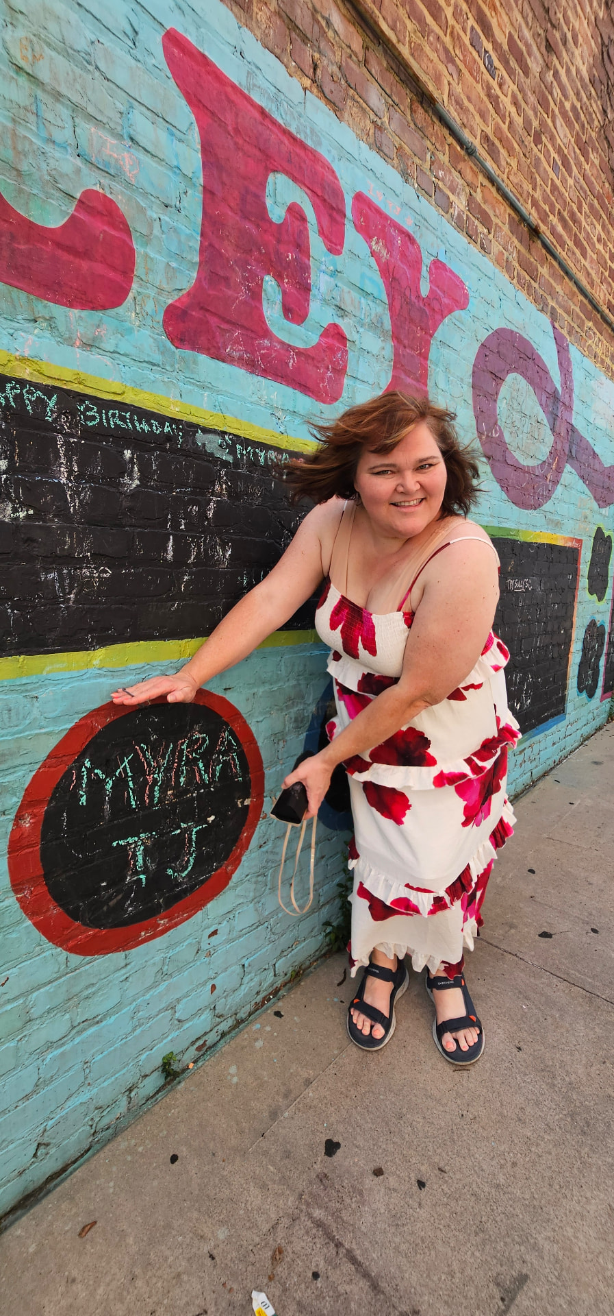 Myra beside a chalk wall with her and TJ's names