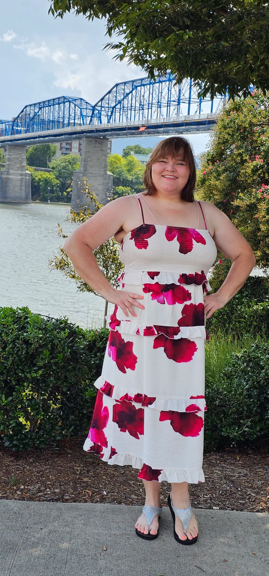 Myra laughing with her hands on her hips by the water